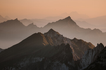 Foggy sunset with beautiful silhouette of mountain range in Switzerland