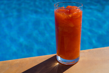 fresh persimmon fruit drink in the mediterranean summer sun by the pool