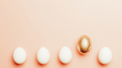 Easter background. Golden, white colour egg on pastel pink background in Happy Easter decoration. Spring holiday top view concept.