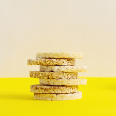 Rice and buckwheat cakes on a yellow background. Dumbbells on a white background, healthy lifestyle.