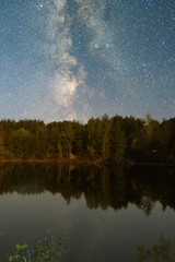 Fototapeta na wymiar Lake with campfire at night starry sky 