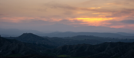 Panoramic mountain landscape with cloudy sky at sunset