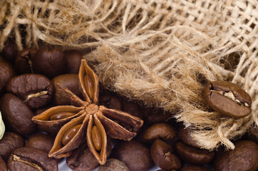 Blurred background, texture. Brown roasted coffee beans, star anise,seeds on a burlap textile background. Espresso is a dark, aromatic, black caffeine drink. Close-up isolated mocha energy.