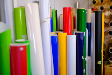 many colorful adhesive foils stand on the wall of a design studio
