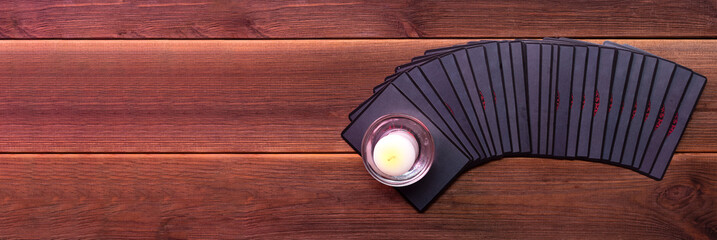 Fortune-telling cards on a wooden table with one candle. Divination concept, tarot cards, psychic