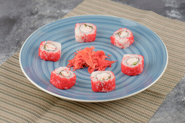 California sushi rolls and pickled ginger on blue plate