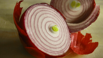 Red onion cut in half exposing onion layers and green heart