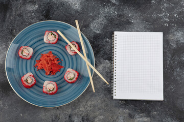 California sushi rolls and pickled ginger on blue plate