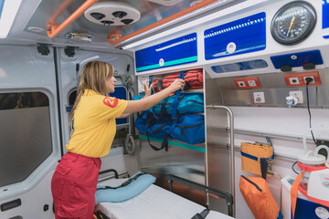 a young female sanitary prepares an ambulance to go out and do an emergency service