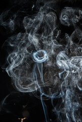 Abstract puffs of smoke on a black background.