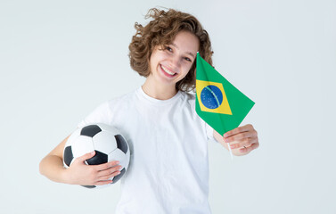 Young woman with Brazil flag and soccer ball, isolated on gray background.