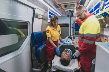 a medical team in an ambulance helps an adult man