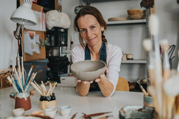 young artisan woman working with her hand a piece of ceramic