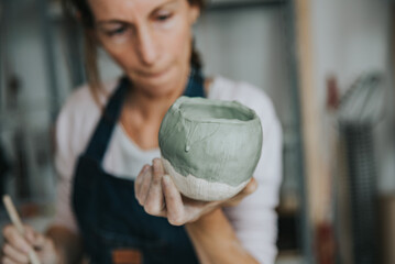 young artisan woman working with her hand a piece of ceramic focus on hand