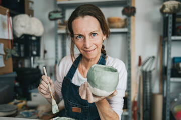 young artisan woman working with her hand a piece of ceramic