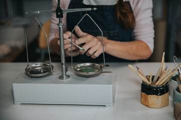 young artisan woman working with her hands a piece of ceramic mixing colors focus on hand
