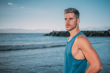 a young man exercises on the beach at sunset on a beach