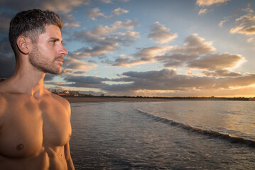 a young man exercises on the beach at sunset on a beach. Warm colors