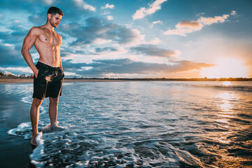 a young man exercises on the beach at sunset on a beach. Warm colors