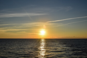 Sunset over the calm sea in a cloudy sky. Abstract and dramatic sunset sky.