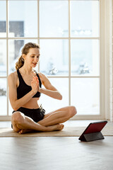 woman practicing online yoga with tablet