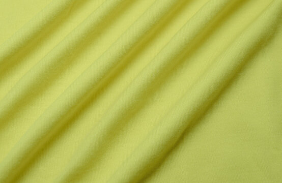 Soft And Comfortable Pastel Yellow Fabric. Stretchy Cotton Fabric Surface Texture With Wavy Folds And Diagonal Stripes. Bright Colors Shot From Above