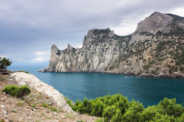 Fototapeta na wymiar The Black Sea coast near Novy Svet, South-Eastern Crimea. View of Sky-Blue Bay, the Turtle Head Mountain (left), Cosmos Peak (center) and Mount Karaul-Oba (right).
