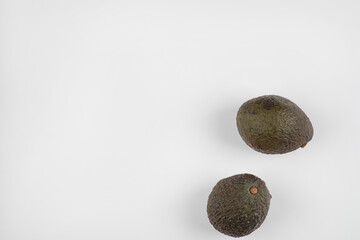 Two fresh healthy brown avocado isolated on white-gray background