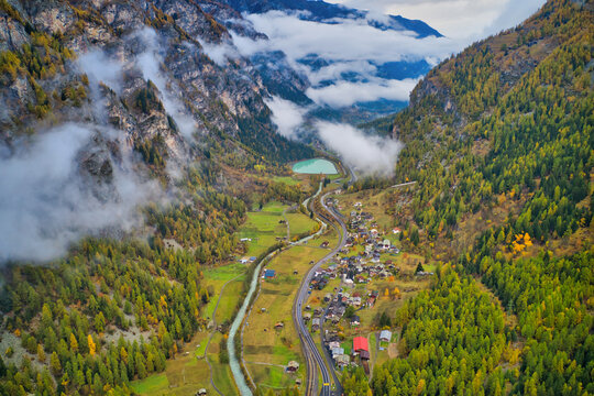 Aerial view of a waving road in countryside going to Ardon township with mountain range in background, Ardon, Switzerland.