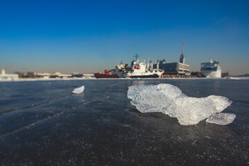 Massive different ship vessels trapped in ice tries to break and leave the bay between the glaciers, icebreaker and carrier vessel, winter blue sky view