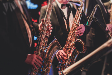 Obraz premium Concert view of a saxophonist, saxophone sax player with vocalist and musical during jazz orchestra performing music on stage