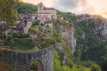 Fototapeta na wymiar Sunset or sunrise view of the scenic hilltop medieval French village of Saint-Cirq-Lapopie, France with the fortified church above the Lot River.