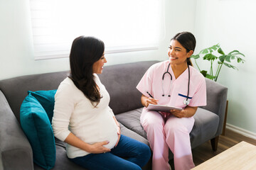 Female doctor and expectant mother laughing during a check-up