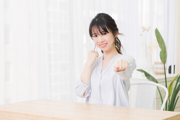 部屋でパンチのジェスチャーをする若い女性