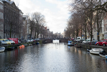 Amsterdam canal with boats and European buildings and trees
