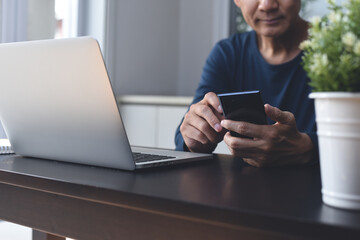 Work from home. Casual business man using mobile phone during online working on laptop computer from home office