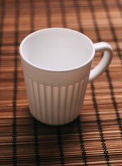 white mug on a wooden stand stands on the table top view