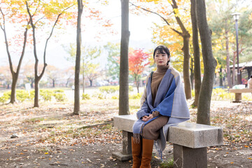 Fototapeta premium 秋の公園にたたずむ女性 