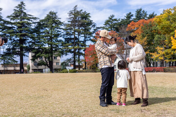 Fototapeta premium 秋の公園を散歩する家族・ファミリー 