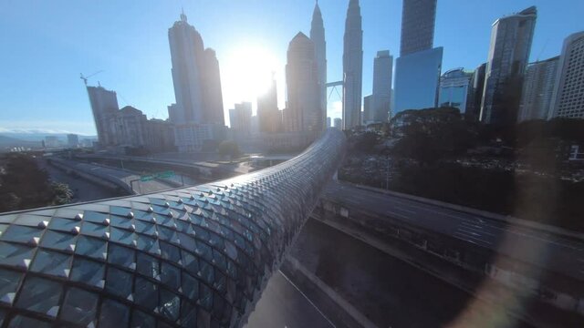 fpv drone view of kuala lumpur pedestrian bridge over speedway highway from city center to village area