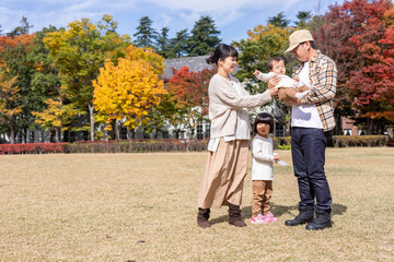 Fototapeta premium 秋の公園を散歩する家族・ファミリー 