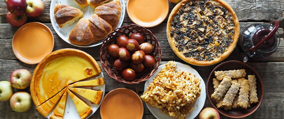 Easter treats, pastries and eggs on an ancient wooden table.