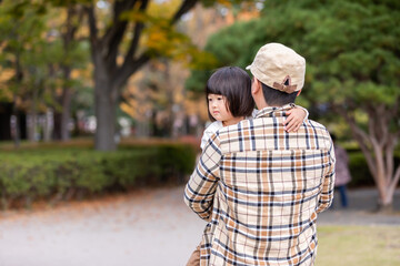 秋の公園で遊ぶ父親と子供
