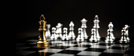 King chess standing to fight battle combat with silver chess on chess board. Concepts of business team and leadership strategy and organization risk management.
