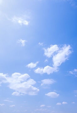 Sunny weather, white clouds and blue sky background, vertical