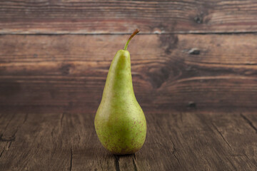 Single tasty fresh pear placed on wooden surface