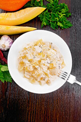 Pumpkin with sour cream sauce in plate on wooden table top