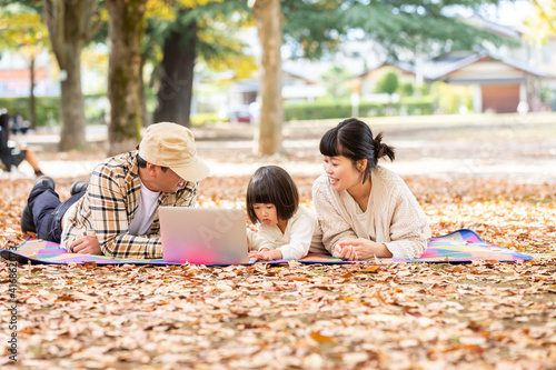 秋の公園でママとタブレットpcで遊ぶ赤ちゃん Wall Mural Buritora