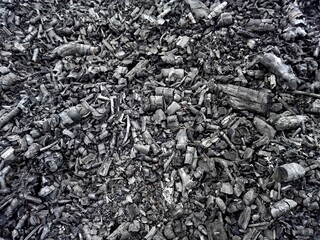 Black ash charcoal from oven background texture, gray wood ash coal in fireplace. Pile of ash charcoal after fire. Burned out wood charcoal in bbq stove grunge light black natural background texture