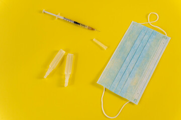 Flat Lay for medical theme and vaccinations from COVID-19. Medicine, vaccine, syringe, mask.